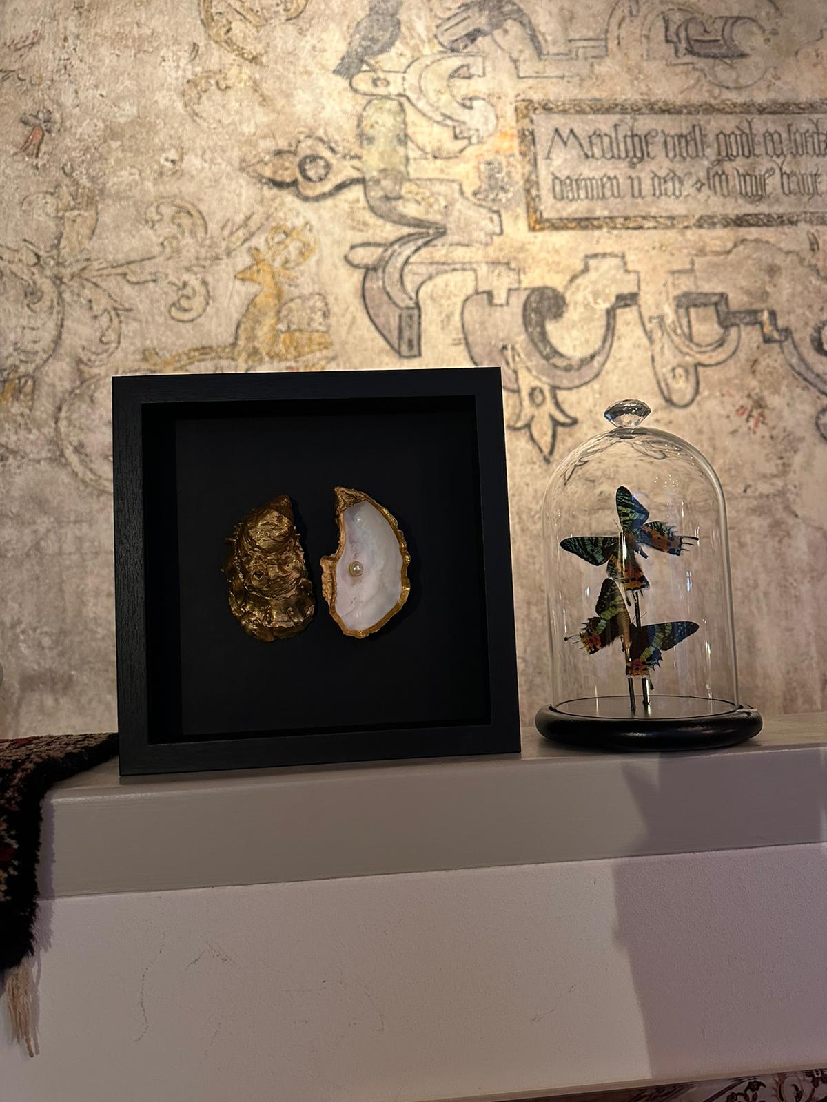 Gouden oester in lijst dubbel met parel - zwart achtergrond