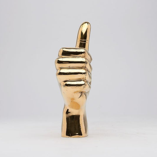 Hand met duim omhoog in gepolijst messing