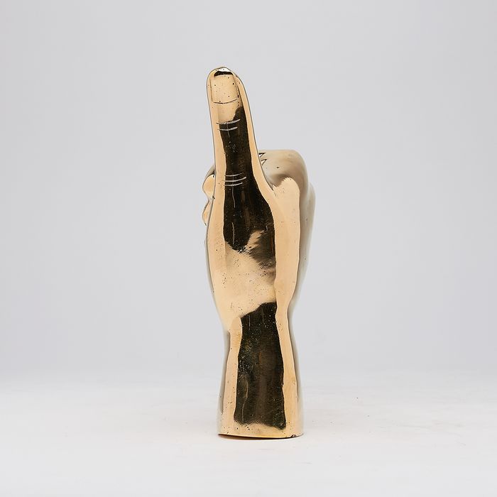 Hand met duim omhoog in gepolijst messing